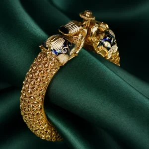 This handcrafted 22K gold-plated bracelet features a striking dual panther-head design with deep blue enamel and black stone eyes, exuding a bold yet regal aura for bridal and festive wear.
