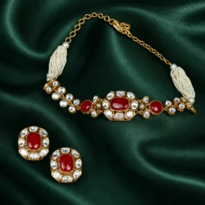This handcrafted choker set features an ruby red square stone, white Kundan drops, multi-strand white pearl beading, and matching earrings. A premium traditional jewellery set for women & girls for festive and wedding occasions.